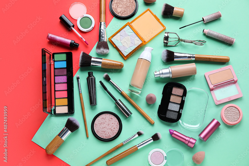 Wooden makeup brushes with decorative cosmetics on color background