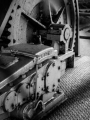 Canvas Print - A grayscale closeup of gears of a  heavy machine on metal ground