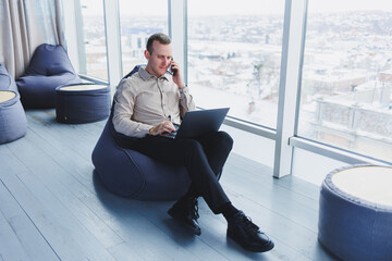 young smart male businessman is sitting in the office and working on a project related to public cyb