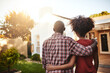 © Delmaine Donson/peopleimages.com - What a lovely place to call our home. Rear view shot of a young couple admiring their new house outside.