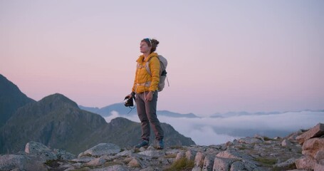 cinematic sunset shot of young woman adventurer on evening midnight sun hike shoot content on profes