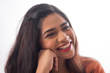 Wall Mural - Close-up portrait of smiling woman with hand on cheek