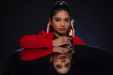 Wall Mural - Young woman looking at camera with mirror reflection