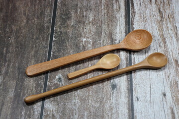 Pile of wooden spoon (utensil) on the wooden background. Vintage kitchenware concept. 