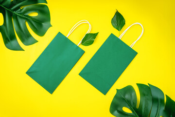 Set of multiple disposable paper bags for takeaway food, gifts,and mock up.Eco-friendly paper bags on yellow background.Recycled paper shopping bag with green leaves .