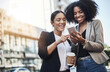 © Delmaine Donson/peopleimages.com - Reaching out to new networks. Shot of two businesswomen looking at something on a cellphone in the city.