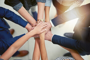 Wall Mural - Making business better together. Closeup shot of a group of businesspeople joining their hands together in unity.