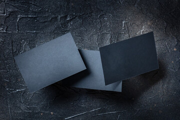 Wall Mural - Black business card mock up on a dark background, a template for design presentation, thick cardboard visiting cards levitating on black
