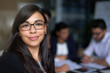 © Lucinda D B/peopleimages.com - Shes a standout in the office. Portrait of a smiling young businesswoman in an office with colleagues in the background.