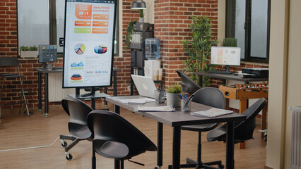 Wall Mural - Empty brick wall office with no people at meeting table, business space with modern decorations and technology. Nobody in company workplace with monitor for work presentation.