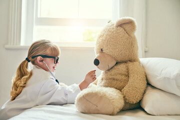 Thats a good heart you have there, teddy. Shot of an adorable little girl dressed up as a doctor and examining a teddy bear with a stethoscope.