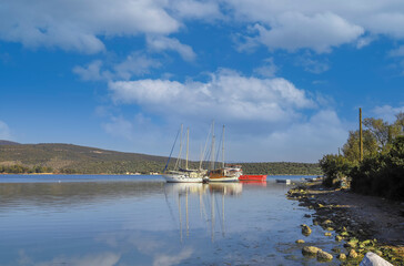 Wall Mural - Boats moored in the sea and their reflections on a sunny day