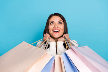 Sticker - Photo of shiny impressed lady dressed white cardigan holding shoppers looking empty space isolated blue color background