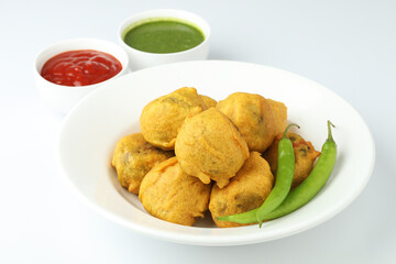 Wall Mural - Indian snack aloo vada or bonda made from potato with coconut chutney. Indian snacks Aloo Bonda vada, pakoda, pakora.Paneer bonda indian snack, Served with tomato sauce placed 