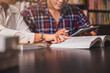 © Sirichai - studen sitting pointing, studying and checking, tutoring books with college students friends. Teaching helping and study course, Team of young teacher or tutor helps students to learning in classroom.