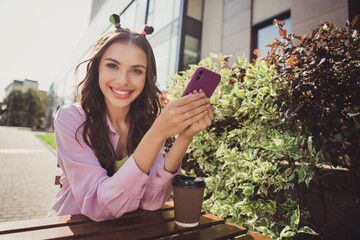 Sticker - Photo of cute millennial brunette lady wear pink shirt look telephone drink coffee in cafe outside town