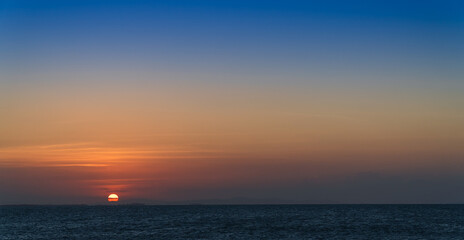 Wall Mural - sunset over the sea in the evening with orange sunlight and sundown, dusk sky