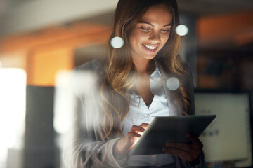 Aufkleber - Working hard no matter the time. Shot of a young attractive businesswoman working late at night in a modern office.