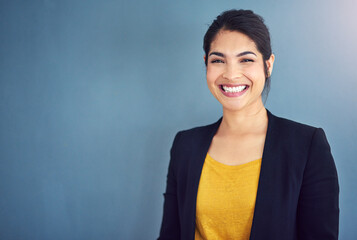 Confidence is the key to success. Studio portrait of an attractive young businesswoman standing against a blue background.