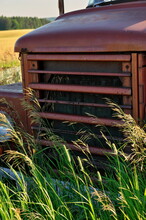 Close Up Of Front Grill Of Abandoned Vintage And Rusty Truck In A Field On A Sunny Day