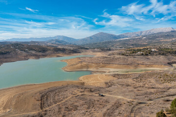 Canvas Print - An aerial view of Lake Vinuela in the backcountry mountains of Malaga Province with a tiny camper van below