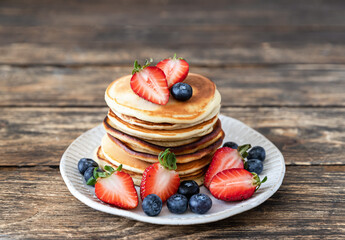 Pancakes with berries and honey. Delicious weekend breakfast