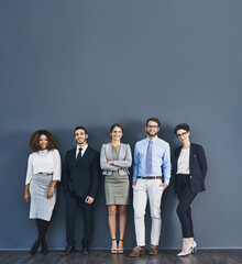 Aufkleber - Corporate confidence at its best. Studio shot of a group of businesspeople standing in line against a gray background.