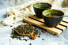 Two Cups Of Green Sencha Tea With Dried Mango