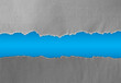 © Stillfx - Ripped grey paper on blue background, space for copy