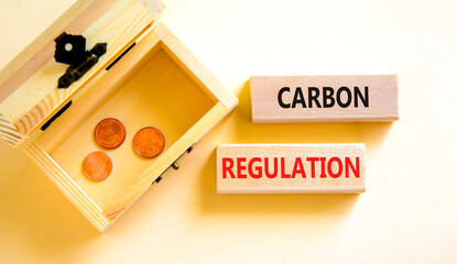 Wall Mural - Carbon regulation symbol. Concept words Carbon regulation on wooden blocks on a beautiful white table white background. Wooden chest with coins. Business and carbon regulation concept, copy space.