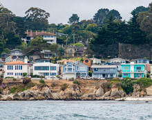 Houses In Pacific Grove, California (in Monterey County) Overlook The Rocky Coastline, As Viewed From A Passing Boat.