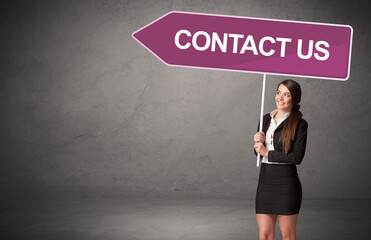 Young business person in casual holding road sign