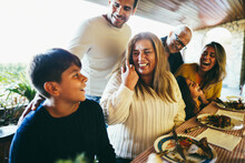 Happy Latin Family Eating Lunch Together At Home - Soft Focus On Grandmother Face
