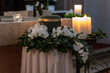 Urne mit Orchideenkranz und Kerzen