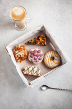 Assorted Cakes In A Paper Box On A Gray Light Background