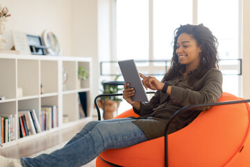 Wall Mural - Portrait of smiling black woman using tablet at home