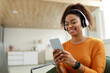© Prostock-studio - Happy black woman using cellphone wearing headphones