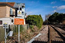 Warning Signs On A Level Crossing Informing The Public To Beware Of Trains And That Trespassing On The Tracks Will Lead To Prosecution And A Fine To Pay