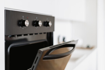 Stylish oven with open door in Nordic style kitchen