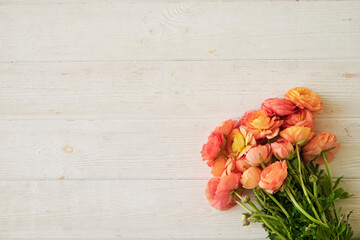 Wall Mural - Close up shot of beautiful orange and red ranunculus bouquet. Visible petal structure. Detailed bright patterns of flower buds. Top view, background, copy space for text.