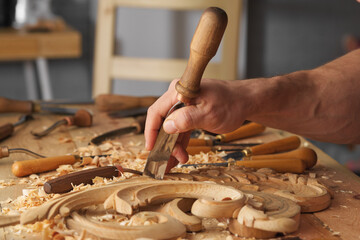 Poster - Woodworking tools. Carving wood with chisel. Carpenter's hands use chiesel