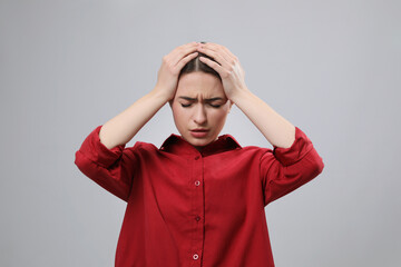 Poster - Woman suffering from headache on light grey background. Cold symptoms