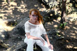 red-haired girl in a white dress with long hair in glasses in the forest