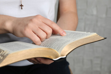 Wall Mural - Woman reading Bible against white wall, closeup