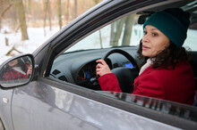 Portrait Of A Confident African American Woman Traveler Driver, Driving Car In A Snow-covered Woodland.
