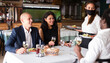 © JackF - smiling female waiter bringing order to group of friens in restaurante during virus