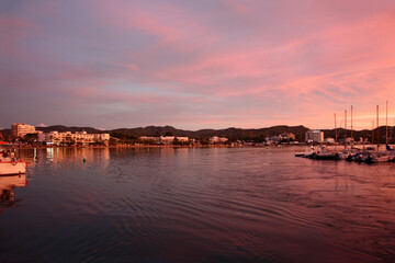 romantic pink sunset over the sea waters of the port of san antonio in ibiza