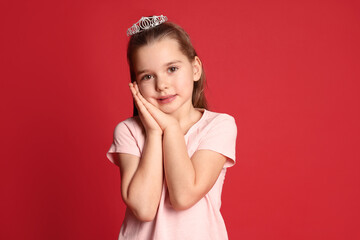 Poster - Cute girl in diadem on red background. Little princess