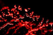 Drops Of Water Splash Red Water On A Black Background, Concept Of Freshness Drink, Watering The Rain Source Of Pure Water Fountain Copy Space