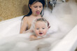 Cute sibling children bathe in a bubble bath together. Children in the bathroom. The concept of hygiene and education.